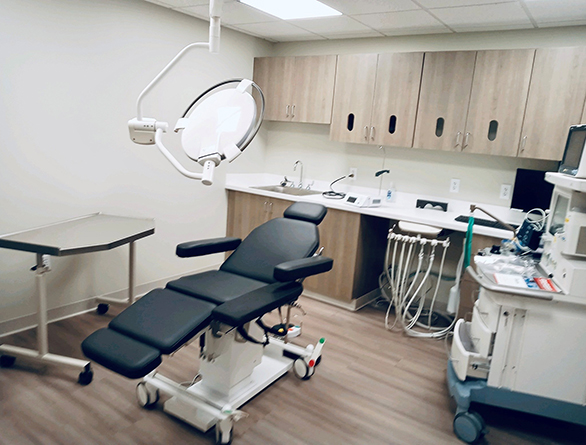 Modern dental operatory room with treatment chair, overhead light, and surgical equipment at Capitol Oral Surgery.